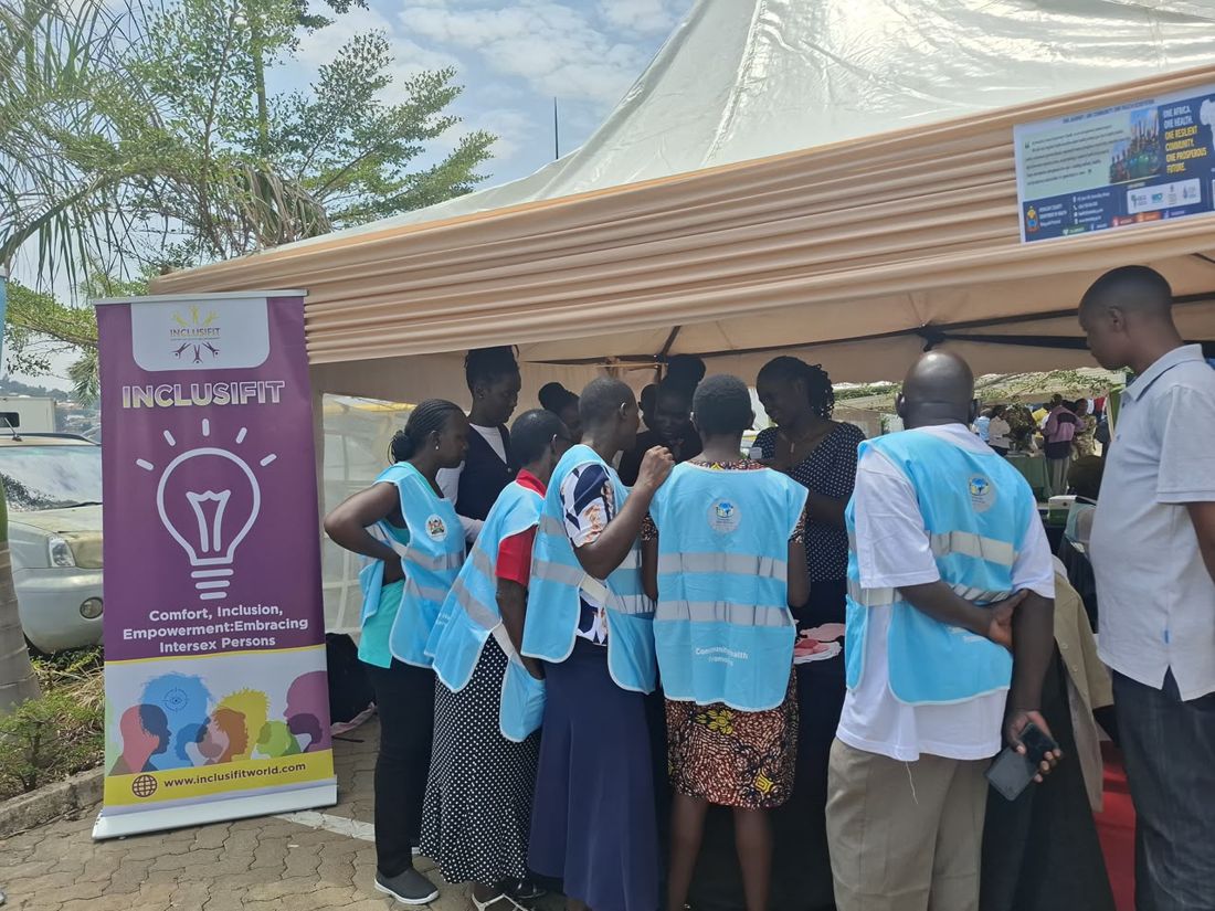Participants gathered around the InclusiFit banner.