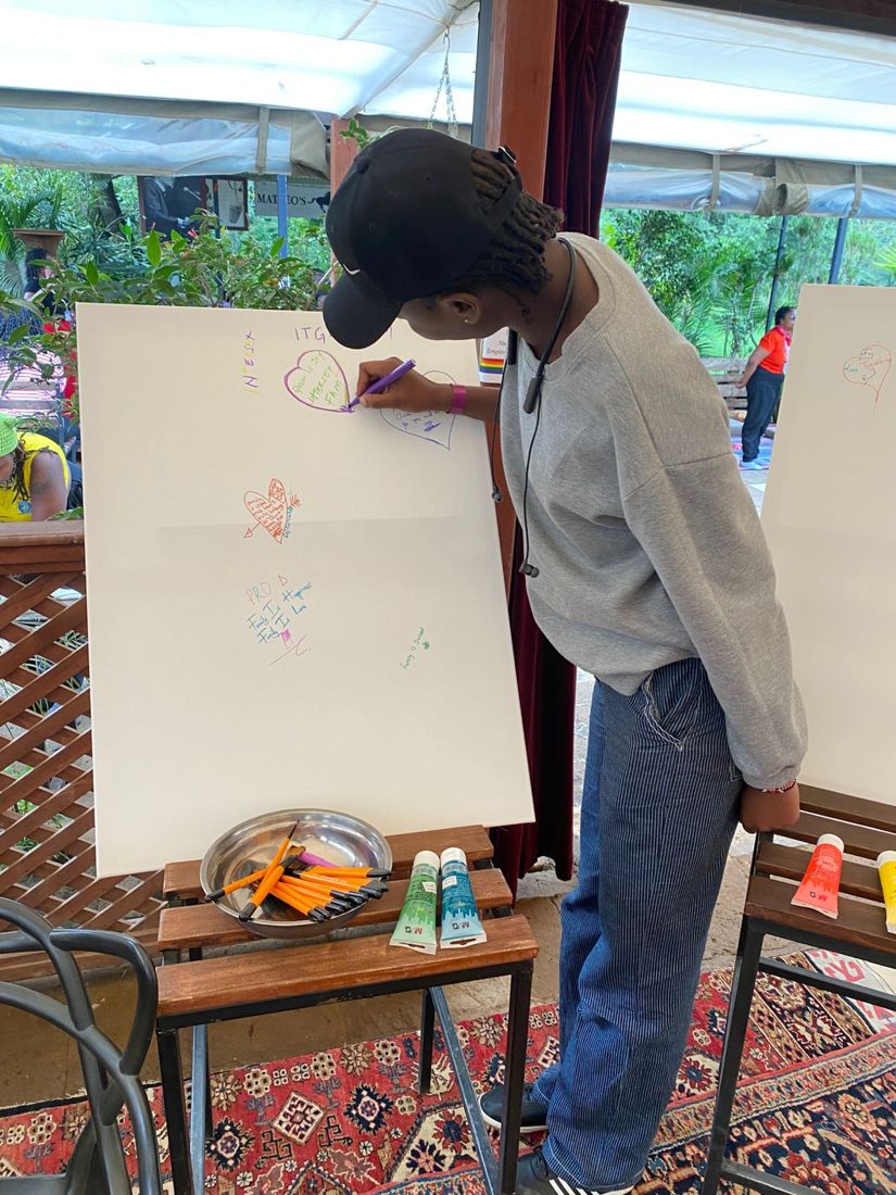 A participant writing affirming messages on the community expression board.